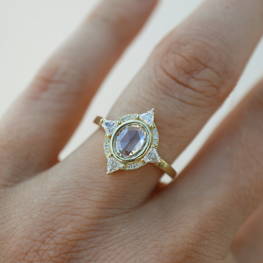 White Diamond sapphire engagement ring on model’s ring finger.