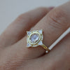 White Diamond sapphire engagement ring on model’s ring finger.